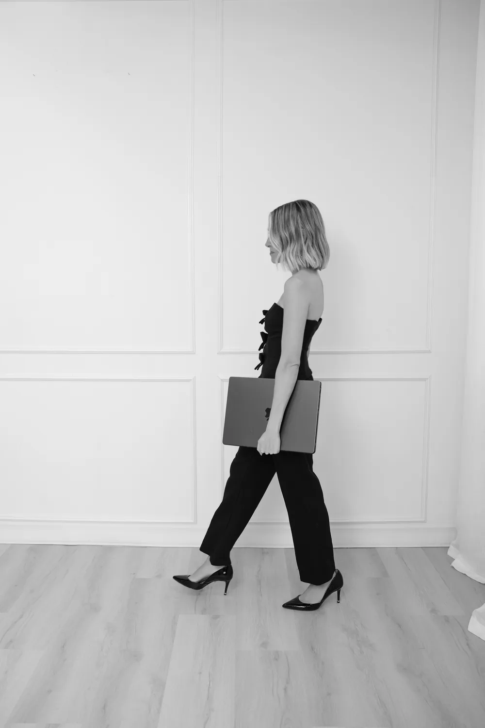 Alyson walking with a laptop folio