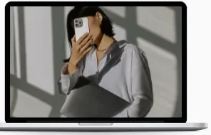 Laptop showing a woman holding a phone