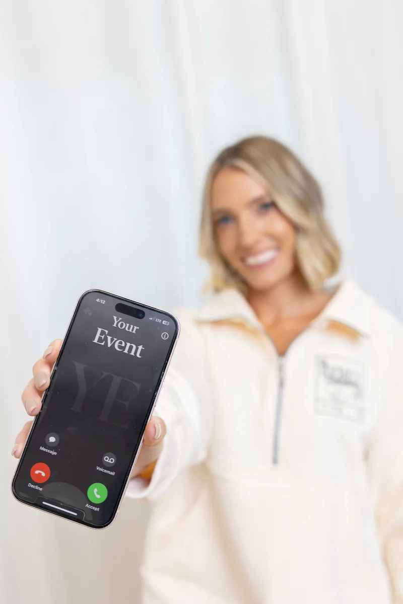 Alyson holding a phone showing an incoming call from "Your Event"